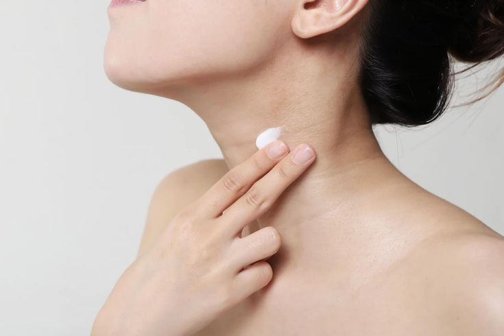 Mujer aplicando crema hidratante en el cuello